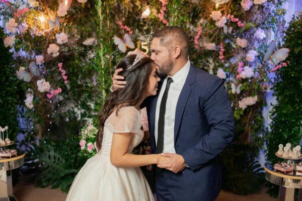 Father kisses his daughter's forehead at her quinceañera