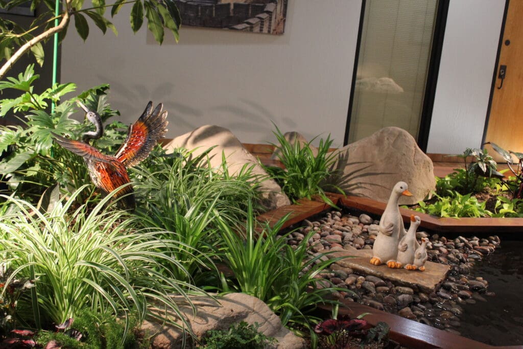 A beautiful heron and some cute ducks enjoy a wetland scene at the Airport Gardens atrium