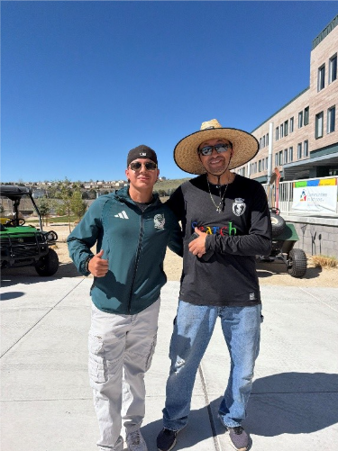 Soccer Co-Coach Ismael Delgado and Soccer Coach Nico Moreno pose outside Hug High School